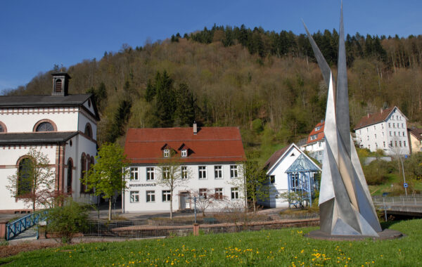 Das Gebäude der Musikschule Schramberg. Im Vordergrund die Stahlplastik von Erich Hauser auf einer Wiese.