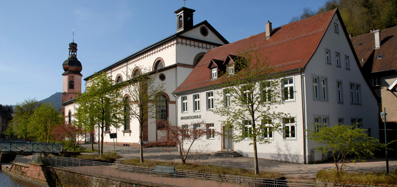 m Hintergrund die Sankt Maria Kirche. Vorne der Bach Schiltach.