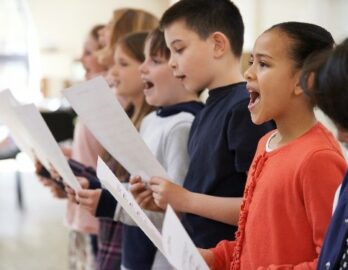 Hier sieht man singende Kinder.