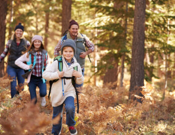 Eine fröhliche Familie wandert im herbstlichen Wald