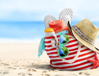 Zu sehen ist eine Strandtasche mit verschiedenen Utensilien.